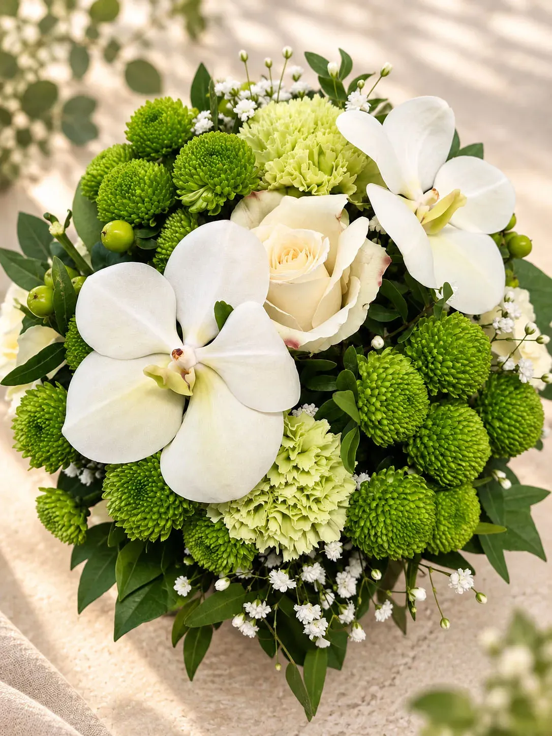 Klein rond bloemstukje met witte en groene tinten