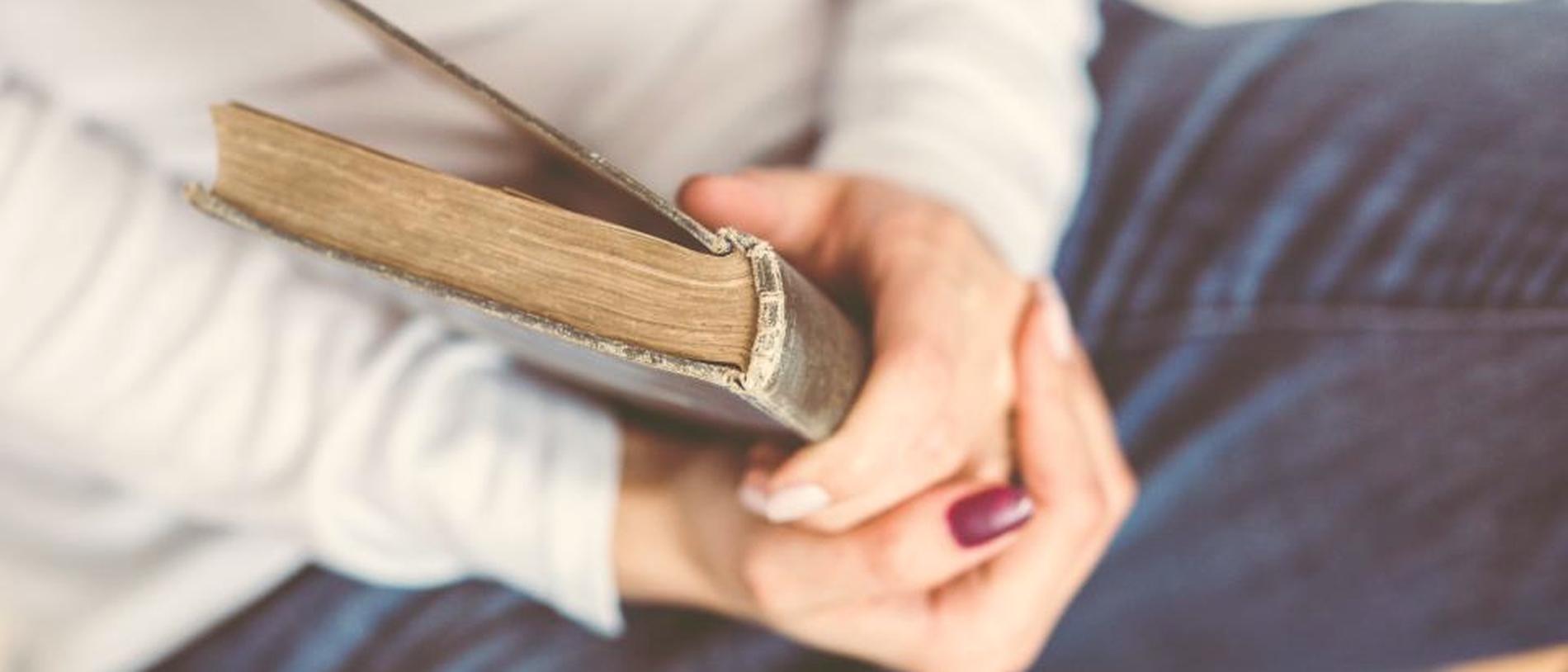 Handen die rustig een boek vasthouden